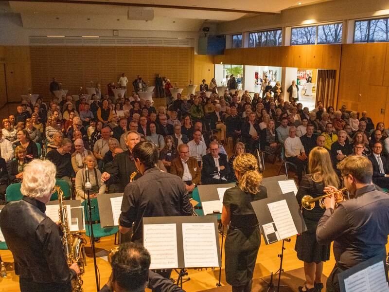 das Ensemble des Musikvereins von hinten Blick von Bühne in voll besetzte Halle