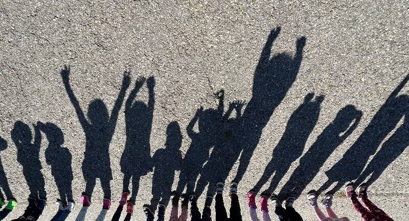 Bild von einem Schatten, von einigen Kindern die nebeneinander stehen.