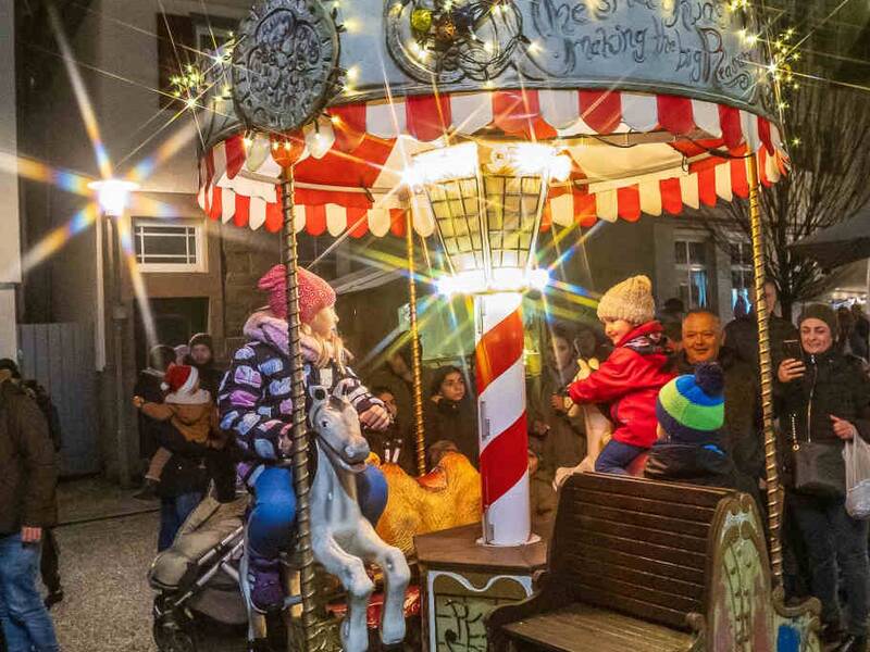 Kinder auf einem Kinderkarussell auf dem Weihnachtsmarkt 