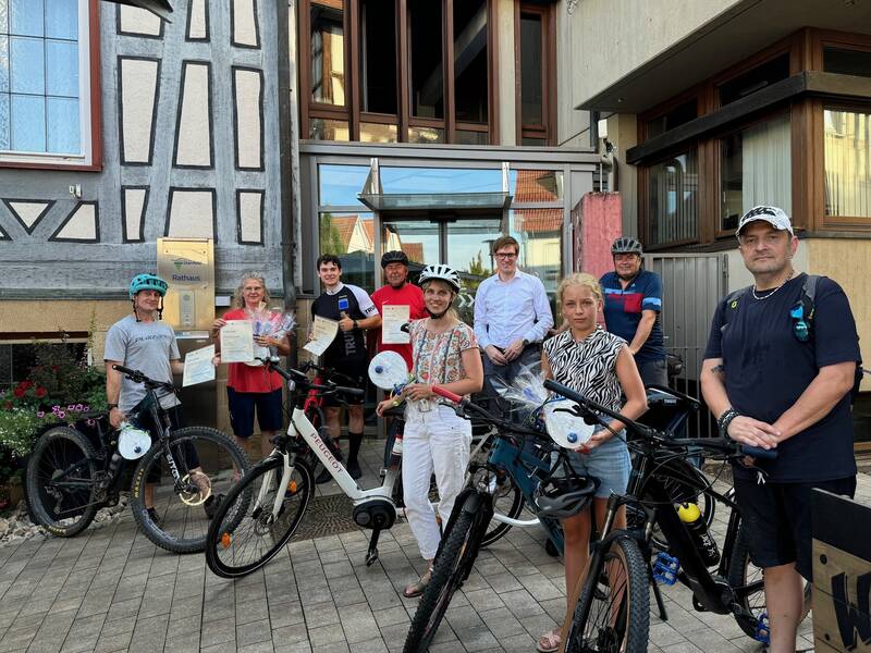 Teilnehmende am Stadtradeln stehen mit Helmen und Fahrrädern vor dem Rathaus Oberstenfeld