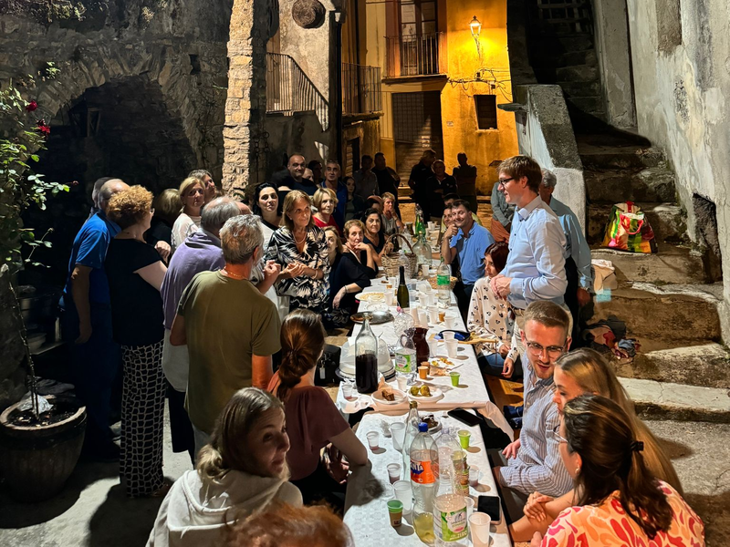 Gemeinsames Abendessen an langer Tafel mit vielen Flaschen und Gläsern in den Altstadtgassen von Verbicaro